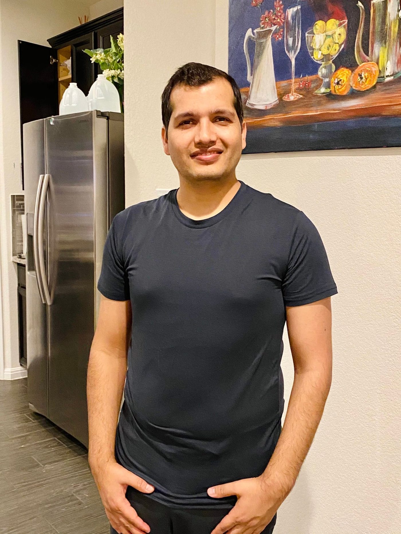 Pradeep Gautam, self-taught artist from Nepal based in Austin, Texas, beside his painting
